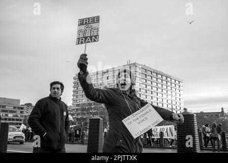 Britisch-Iraner und Anhänger säumten beide Seiten der Westminster Bridge mit Plakaten, während sie Protestlieder gegen die herrschende Islamische Republik im Iran und das Verhalten des IRGC sangen und sangen. Am 16. September 2022 starb die 22-jährige iranische Frau Mahsa Amini, auch bekannt als Jina Amini, an Verletzungen, die sie in Gewahrsam der religiösen Moralpolizei der iranischen Regierung erhalten hatte. Der Tod von Amini führte zu einer Reihe von Protesten im ganzen Iran gegen die herrschende Islamische republik. Stockfoto