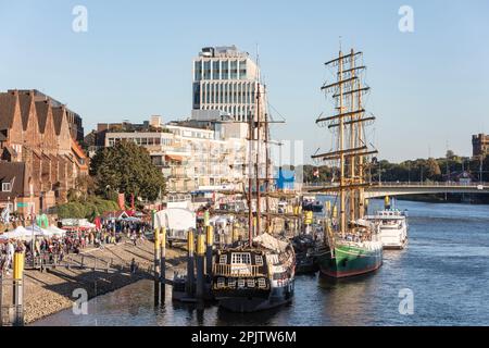 People at Maritime Day - Maritime Woche in Cafés und Bars an der historischen Promenade am Weser mit Booten und Großseglern. Bremen. Stockfoto