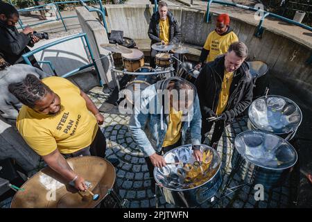 Steel Pan Music-Band spielt als Little Amal, die riesige 10 Jahre alte Marionette der iranischen Flüchtlinge besucht Alexandra und Ainsworth Estate im Norden Londons. Stockfoto