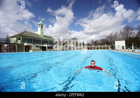 Peterborough, Großbritannien. 30. März 2023. Der diensthabende Manager Mason Matchwick genießt ein Bad im Peterborough Lido, der sich auf die Eröffnung der Sommersaison am 1. April in Peterborough, Cambridgeshire, Großbritannien, vorbereitet. Die Peterborough Cathedral ist nur wenige hundert Meter vom Peterborough Lido entfernt, der 1936 erbaut wurde, und der Außenpool hat noch heute den fabelhaften Art-Deco-Look. Kredit: Paul Marriott/Alamy Live News Stockfoto