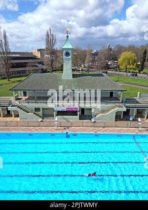 Peterborough, Großbritannien. 30. März 2023. Der diensthabende Manager Mason Matchwick genießt ein Bad im Peterborough Lido, der sich auf die Eröffnung der Sommersaison am 1. April in Peterborough, Cambridgeshire, Großbritannien, vorbereitet. Die Peterborough Cathedral ist nur wenige hundert Meter vom Peterborough Lido entfernt, der 1936 erbaut wurde, und der Außenpool hat noch heute den fabelhaften Art-Deco-Look. Kredit: Paul Marriott/Alamy Live News Stockfoto