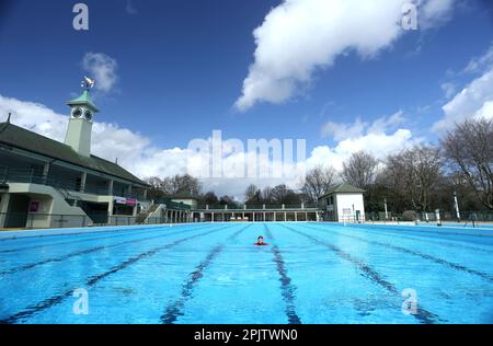 Peterborough, Großbritannien. 30. März 2023. Der diensthabende Manager Mason Matchwick genießt ein Bad im Peterborough Lido, der sich auf die Eröffnung der Sommersaison am 1. April in Peterborough, Cambridgeshire, Großbritannien, vorbereitet. Die Peterborough Cathedral ist nur wenige hundert Meter vom Peterborough Lido entfernt, der 1936 erbaut wurde, und der Außenpool hat noch heute den fabelhaften Art-Deco-Look. Kredit: Paul Marriott/Alamy Live News Stockfoto