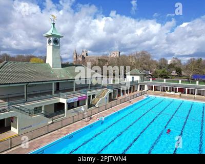 Peterborough, Großbritannien. 30. März 2023. Der diensthabende Manager Mason Matchwick genießt ein Bad im Peterborough Lido, der sich auf die Eröffnung der Sommersaison am 1. April in Peterborough, Cambridgeshire, Großbritannien, vorbereitet. Die Peterborough Cathedral ist nur wenige hundert Meter vom Peterborough Lido entfernt, der 1936 erbaut wurde, und der Außenpool hat noch heute den fabelhaften Art-Deco-Look. Kredit: Paul Marriott/Alamy Live News Stockfoto