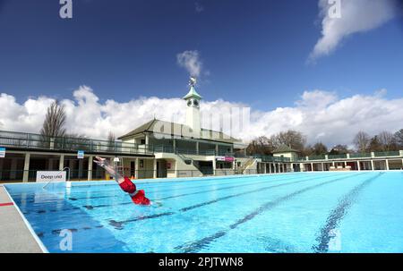 Peterborough, Großbritannien. 30. März 2023. Der diensthabende Manager Mason Matchwick genießt ein Bad im Peterborough Lido, der sich auf die Eröffnung der Sommersaison am 1. April in Peterborough, Cambridgeshire, Großbritannien, vorbereitet. Die Peterborough Cathedral ist nur wenige hundert Meter vom Peterborough Lido entfernt, der 1936 erbaut wurde, und der Außenpool hat noch heute den fabelhaften Art-Deco-Look. Kredit: Paul Marriott/Alamy Live News Stockfoto