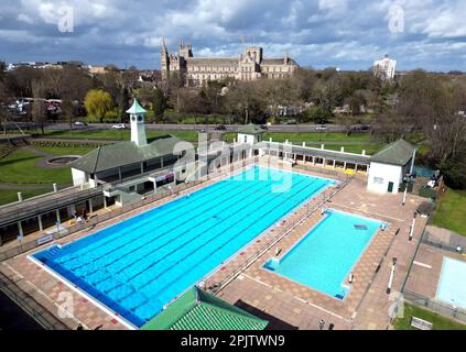 Peterborough, Großbritannien. 30. März 2023. Der diensthabende Manager Mason Matchwick genießt ein Bad im Peterborough Lido, der sich auf die Eröffnung der Sommersaison am 1. April in Peterborough, Cambridgeshire, Großbritannien, vorbereitet. Die Peterborough Cathedral ist nur wenige hundert Meter vom Peterborough Lido entfernt, der 1936 erbaut wurde, und der Außenpool hat noch heute den fabelhaften Art-Deco-Look. Kredit: Paul Marriott/Alamy Live News Stockfoto