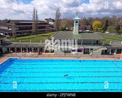 Peterborough, Großbritannien. 30. März 2023. Der diensthabende Manager Mason Matchwick genießt ein Bad im Peterborough Lido, der sich auf die Eröffnung der Sommersaison am 1. April in Peterborough, Cambridgeshire, Großbritannien, vorbereitet. Die Peterborough Cathedral ist nur wenige hundert Meter vom Peterborough Lido entfernt, der 1936 erbaut wurde, und der Außenpool hat noch heute den fabelhaften Art-Deco-Look. Kredit: Paul Marriott/Alamy Live News Stockfoto