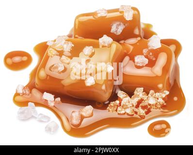 Salzige Karamellbonbons in Milchkaramellsauce mit Salzkristallen auf weißem Hintergrund. Stockfoto