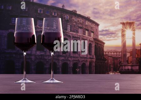 Ein Glas Rotwein mit Blick auf den Sonnenuntergang über dem Kolosseum in Rom, Italien Stockfoto