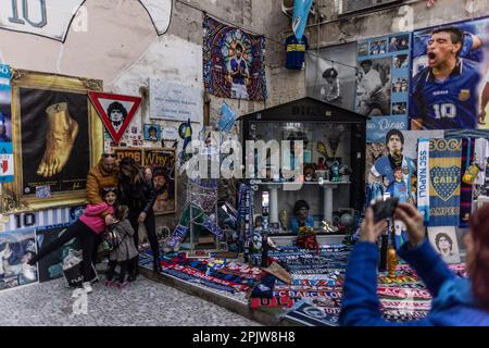 Neapel, Italien. 04. April 2023. Touristen machen Fotos an einem Schrein des ehemaligen argentinischen Fußballers Diego Maradona in der Via Emanuele de Deo. SSC Neapel, dem die Meisterschaft in der aktuellen Saison der Serie A fast unmöglich wegzunehmen ist, wurde zuletzt 1990 in Italien mit dem argentinischen Stuperstar Maradona Champion (zu dpa „Neapel bereit für die größte Fußballmeisterschaftsparty – „wird jeder verrückt?“). Kredit: Oliver Weiken/dpa/Alamy Live News Stockfoto