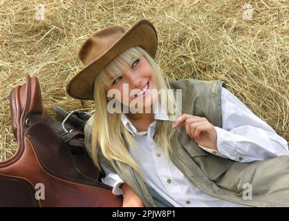 Porträt eines jungen attraktiven Cowgirls auf der Ranch am Sommertag Stockfoto