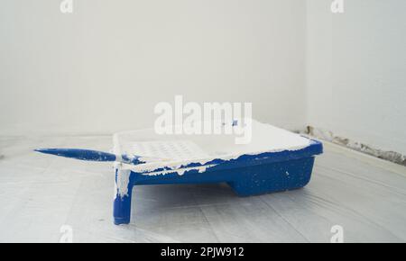 Paint tray with brush and white color paint. Concept of repair and finishing works. Stockfoto