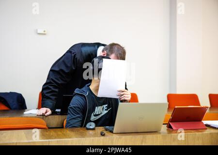 München, Deutschland. 04. April 2023. Ein Mann (Front), der unter anderem des Versuchs beschuldigt wird, eine Explosionszündung zu verursachen, spricht vor Beginn des Prozesses mit seinem Anwalt Kai Wagler in einem Gerichtssaal des Landgerichts München I. Der Angeklagte ist ein mutmaßliches Mitglied einer Bande von ATM-Blastern. Kredit: Matthias Balk/dpa/Alamy Live News Stockfoto