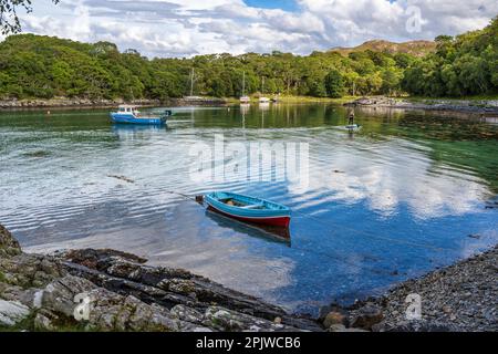 Eine Paddeltour durchquert den geschützten Hafen inmitten von festgefahrenen Booten in der Samalaman Bay in Glenuig auf der Ardnamurchan-Halbinsel in Lochaber, Schottland Stockfoto