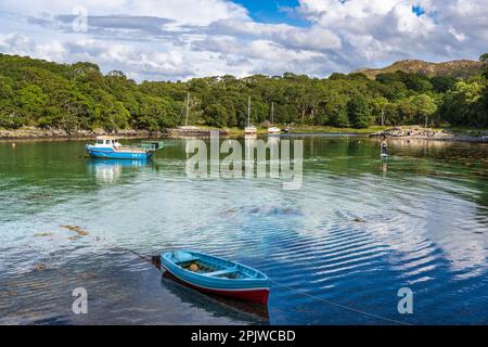 Eine Paddeltour durchquert den geschützten Hafen inmitten von festgefahrenen Booten in der Samalaman Bay in Glenuig auf der Ardnamurchan-Halbinsel in Lochaber, Schottland Stockfoto