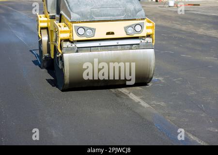 Asphaltfertiger Maschine bei Straßenreparaturen Erneuerung von Straßen, Bauarbeiten Stockfoto