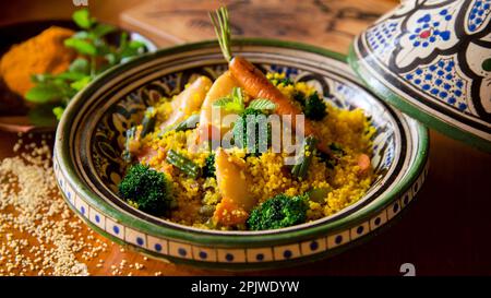 Farbenfroher marokkanischer Tagine mit Currykus mit Calamari, Brokkoli und anderem Gemüse. Stockfoto