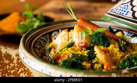 Farbenfroher marokkanischer Tagine mit Currykus mit Calamari, Brokkoli und anderem Gemüse. Stockfoto