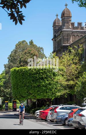 Ein Radfahrer fährt vorbei an den Kuppeltürmen des 1886-87 errichteten Macleay Building an der University of Sydney in Australien. Stockfoto