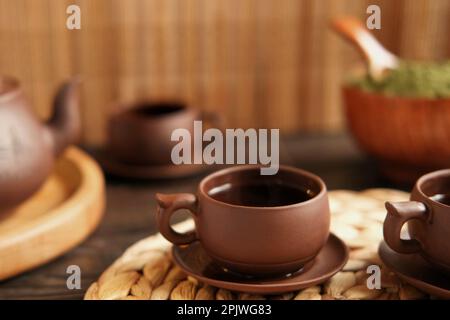 Teezeremonie. Traditionelles Asiatisches Teeutensil, Serviert Authentisches Set. Person, die Tee von der Teekanne aus brauner Keramik bis zur Teekanne einschenkt. Bambusschale. Lifestyle. Wir Stockfoto