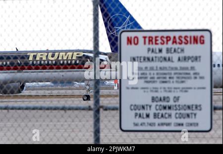 Trumps Flugzeug auf der Rollbahn wartet darauf, dass der ehemalige Präsident Donald Trump am Palm Beach International Airport ankommt, während Unterstützer mit Schildern und Flaggen wedeln Stockfoto