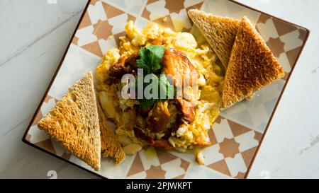 Rührei mit Eiern und Pilzen auf getoastetem Brot. Stockfoto