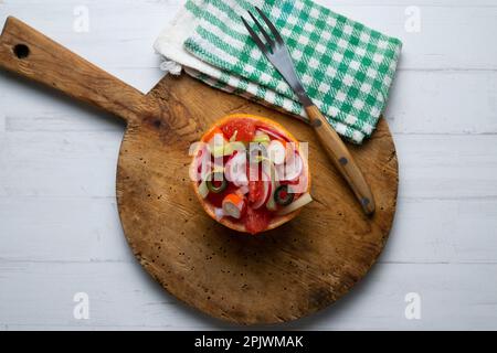 Grapefruit gefüllt mit Surimi-Salat und Radieschen. Stockfoto