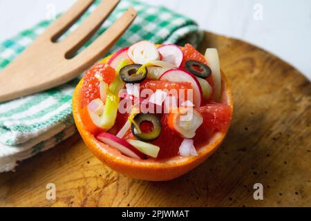 Grapefruit gefüllt mit Surimi-Salat und Radieschen. Stockfoto