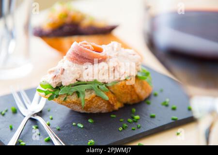 Thunfisch und Sardellen-Tapa. Eine kleine Scheibe Brot, auf die eine kleine Portion des Essens gelegt wird, wird Spieß genannt. Stockfoto