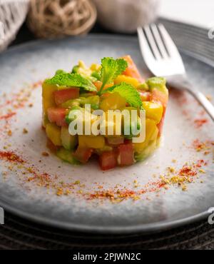 Avocado, Mango und Tomatentartare auf einem Tisch mit Weihnachtsdekorationen. Stockfoto