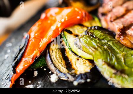 Im Ofen geröstetes Gemüse wie Paprika, Auberginen, Zwiebeln, begleitet von katalanischer Romesco-Sauce. Stockfoto