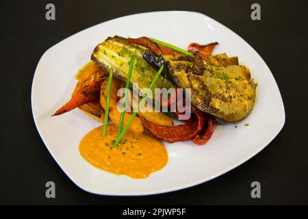 Im Ofen geröstetes Gemüse wie Paprika, Auberginen, Zwiebeln, begleitet von katalanischer Romesco-Sauce. Stockfoto