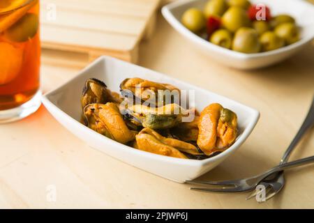 Vermouth ist ein in Kräutern mazerierter Wein, der als Aperitif mit Cockeln, Sardellen, Oliven oder Muscheln eingenommen wird. Stockfoto