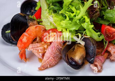 Gourmet-Salat mit Meeresfrüchten, Muscheln, Garnelen und Calamari, serviert mit frischem Grün Stockfoto