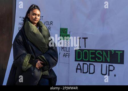 REDAKTIONELLER GEBRAUCH NUR der britische Sänger/Songwriter Joy Crookes steht neben einem Abschnitt des riesigen Belegs, der von einer Plakatinstallation in der Nähe der U-Bahn-Station Finsbury Park in London gedruckt wurde und von der Trussell Trust und der Joseph Rowntree Foundation im Rahmen ihrer „IT doesn't Add Up Campaign“ in Auftrag gegeben wurde. Mit dem Ziel, Probleme nach der Einführung des neuen Universal Credit AMOUNT hervorzuheben. Foto: Dienstag, 4. April 2023. Stockfoto