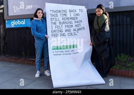 REDAKTIONELLER GEBRAUCH NUR die britische Schauspielerin Charlotte Ritchie (links) und die Sängerin/Songwriterin Joy Crookes besitzen einen riesigen Beleg, der von einer Plakatinstallation in der Nähe der U-Bahn-Station Finsbury Park in London gedruckt wurde und von der Trussell Trust und der Joseph Rowntree Foundation im Rahmen ihrer „IT doesn't Add Up Campaign“ in Auftrag gegeben wurde. Mit dem Ziel, Probleme nach der Einführung des neuen Universal Credit AMOUNT hervorzuheben. Foto: Dienstag, 4. April 2023. Stockfoto