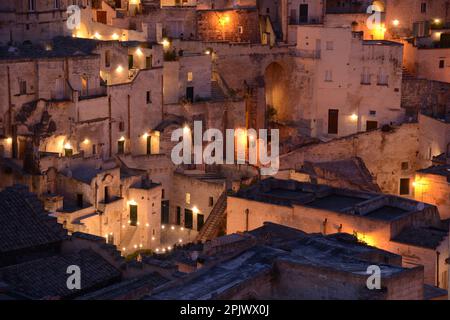 Bei Nacht lassen sich Licht und Blick auf Matera sehen. Matera ist eine Stadt, die sich an einem felsigen Felsvorsprung befindet. Die sogenannte Gegend der Sassi (Stones) ist ein Komplex Stockfoto