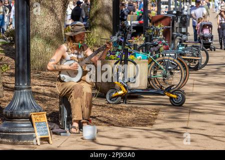 Knoxville, Tennessee, USA - 25. März 2023: Straßenkünstler spielt ein Kazoo und ein Banjo. Im Stadtzentrum. Stockfoto