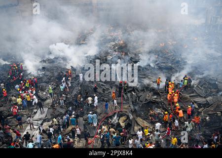 (ANMERKUNG DER REDAKTION: Bild mit einer Drohne aufgenommen)Luftaufnahme von Feuerwehrleuten, Rettungskräften, Einheimischen und Helfern, die ein Feuer auf dem Bangabazar-Markt in Dhaka löschen. Vor Eid-ul-Fitr, einem der größten Bekleidungsmärkte des Landes, hat ein massiver Brand die Geschäfte in Dhakas Bangabazar ausgeplündert. Einsatzkräfte der Armee, der Luftwaffe und der Grenzschutzbeamten Bangladesch haben sich mit 50 Feuerwehr- und Zivilschutzeinheiten zusammengetan, um am Dienstag die Flammen zu zähmen. (Foto: Piyas Biswas/SOPA Images/Sipa USA) Stockfoto