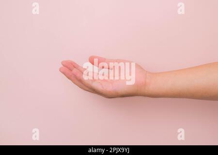 Nahaufnahme männliche Hand, die bereit ist, zu helfen oder zu empfangen, isoliert auf pinkfarbenem Hintergrund. Helfende Hand zur Rettung ausgestreckt. Stockfoto