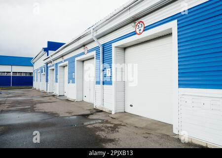 Moderne Garage mit automatischen Toren für Lkw und große Autos. Außenansicht... Stockfoto