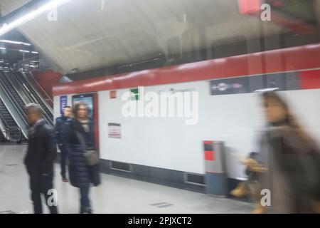 Ein verschwommener Blick auf Menschen, die vom Zug aus gesehen werden, die sich auf dem Bahnsteig des bahnhofs cercanias in Madrid befinden. Stockfoto