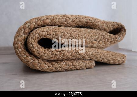 Korbteppich, gefalteter moderner geflochtener Korbteppich auf dem Parkett im Schlafzimmer. Ideenfoto: Korbteppich. Stockfoto