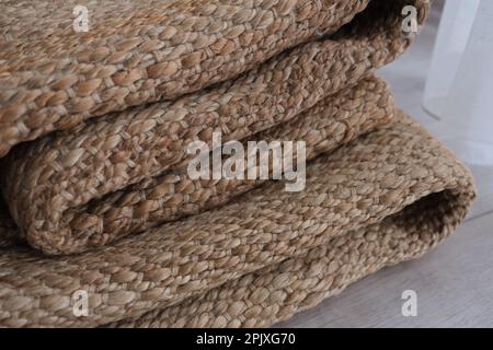 Teppich aus Rattan, moderner natürlicher geflochtener Teppich im Wohnbereich. Ideenfoto: Korbteppich. Umweltfreundliche Innenausstattung in Ihrem Zuhause. Stockfoto