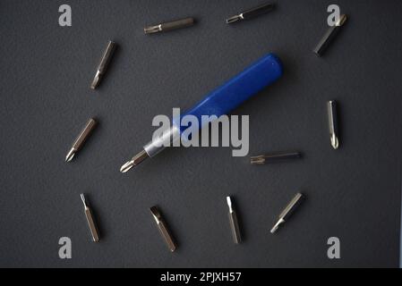 Austauschbare Düsen für einen Schraubendreher. Blauer Schraubendreher mit Aufsätzen. Stockfoto