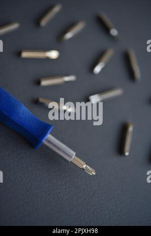 Austauschbare Düsen für einen Schraubendreher. Blauer Schraubendreher mit Aufsätzen. Stockfoto