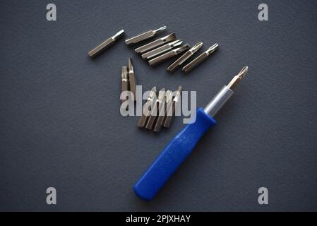 Austauschbare Düsen für einen Schraubendreher. Blauer Schraubendreher mit Aufsätzen. Stockfoto