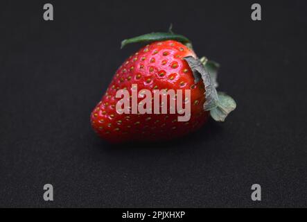 Köstliche große rote Erdbeeren auf schwarzem Hintergrund. Rote Beere. Berry Victoria. Stockfoto