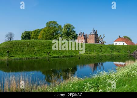 Fesselnder Blick über den Wassergraben über den Deich zum Schloss Slot Loevestein und seiner reichen Geschichte. Die Festung ist die berühmteste in den Niederlanden Stockfoto