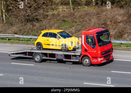 Heritage Spediteure, EV-Car Delivery Experts  Red DAF FA LF45.180 45,170 TAGE 5880 ccm Van mit gelbem 2017 FIAT ABARTH 1368 ccm Benzinmotor 5-Gang-Schaltgetriebe; Fahrt mit Geschwindigkeit auf der Autobahn M6 im Großraum Manchester, Großbritannien Stockfoto