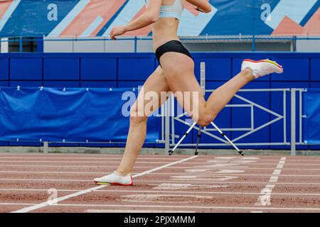 Sportlerin Crosses, Ziellinie-Sprintrennen, Sportmeisterschaften im Sommer im Stadion, Beine Läuferin Stockfoto